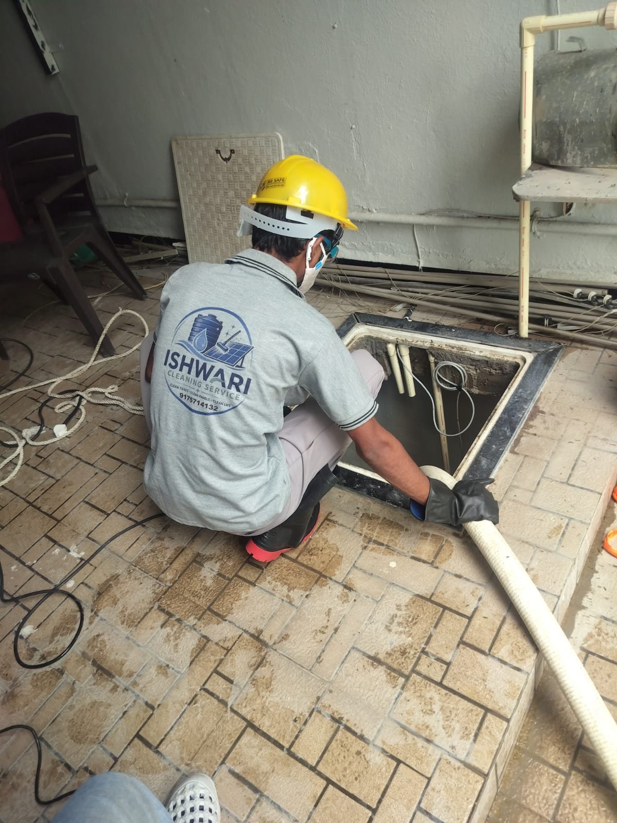 Technician using suction equipment at an underground tank opening